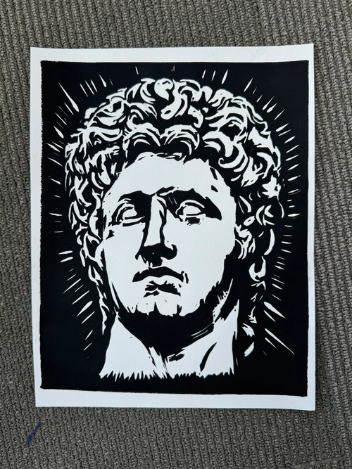 A black and white graphic art print depicting a classical bust of Agustus, shown flat on a textured gray surface.